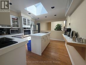 Ramara (Brechin) apartment for rent - A kitchen with white cabinets and a blue trash can.