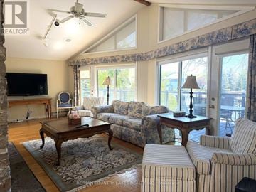 Ramara (Brechin) apartment for rent - A living room with a striped couch and a wooden coffee table.