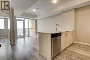 Kitchener condo for rent - A kitchen area with a sink and a refrigerator.