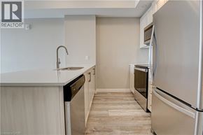 Kitchener condo for rent - A kitchen with a white fridge and a sink.