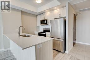 Kitchener condo for rent - A kitchen with a refrigerator, sink, and microwave.