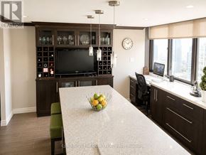 Toronto (Church-Yonge Corridor) condo for rent - A modern kitchen with a large island and a TV mounted above it.
