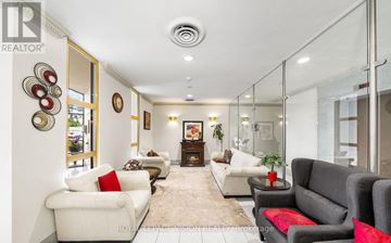 Toronto (Victoria Village) condo for rent - A living room with white furniture and a glass wall.