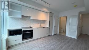 Toronto (Church-Yonge Corridor) condo for rent - A modern kitchen with white cabinets and appliances.