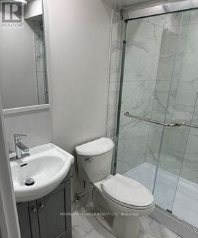 Oshawa (Lakeview) apartment for rent - A white toilet sits next to a sink in a bathroom.