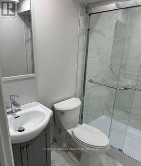 Oshawa (Lakeview) apartment for rent - A white toilet sits next to a sink in a bathroom.