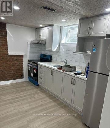 Oshawa (Lakeview) apartment for rent - A kitchen with a stainless steel refrigerator, a black dishwasher, and white cabinets.