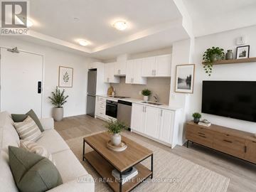 Hamilton (Lakeshore) condo for rent - A living room with a white couch and a wooden coffee table.