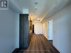 Toronto (Moss Park) condo for rent - A long hallway with wood floors and white walls.
