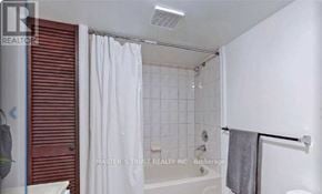 Mississauga (Fairview) apartment for rent - A white bathroom with a red door and a shower curtain.