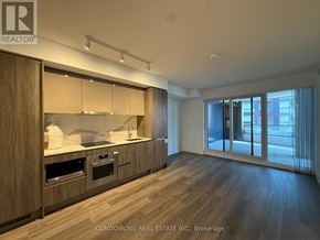 Toronto (Moss Park) condo for rent - A modern kitchen with wooden cabinets and stainless steel appliances.