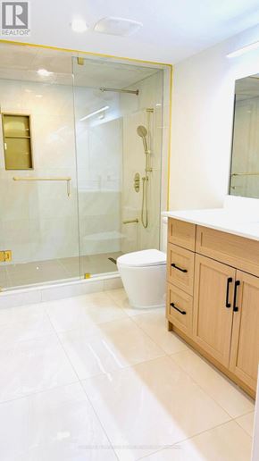 East Gwillimbury (Holland Landing) apartment for rent - A white toilet sits in a bathroom with a walk-in shower.
