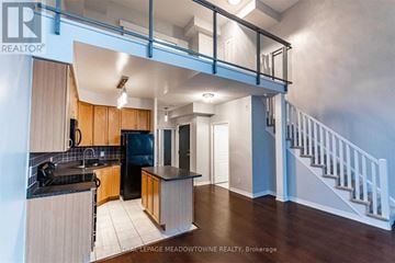 Mississauga (City Centre) condo for rent - A kitchen with wooden cabinets and a black countertop.