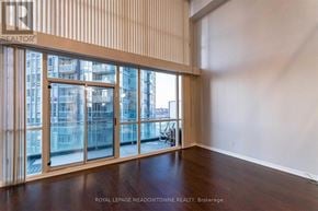 Mississauga (City Centre) condo for rent - A room with a large window and wooden flooring.