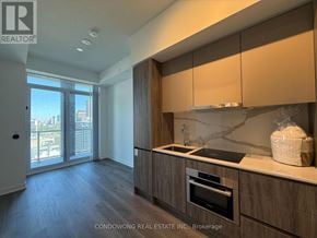 Toronto (Moss Park) condo for rent - A kitchen with wooden cabinets and a marble countertop.
