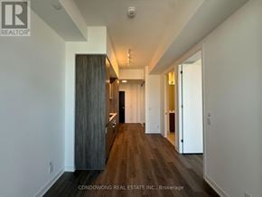 Toronto (Moss Park) condo for rent - A long hallway with wood floors and white walls.