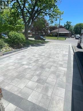 Oshawa (Lakeview) apartment for rent - A paved walkway leads to a building with a brown roof.