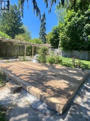 Oshawa (Lakeview) apartment for rent - A wooden deck in a backyard with a fence and trees in the background.