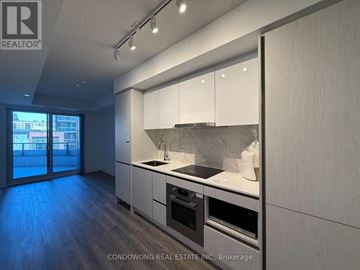 Toronto (Moss Park) condo for rent - A modern kitchen with white cabinets and stainless steel appliances.