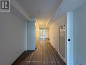Toronto (Moss Park) condo for rent - A long hallway with wood floors and white walls.