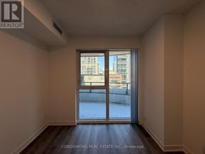 Toronto (Moss Park) condo for rent - A room with a large window and wooden floors.