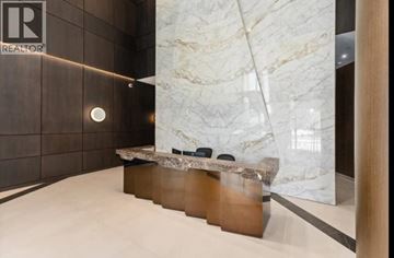 North Vancouver apartment for rent - A reception area with a marble wall and a wooden bench.