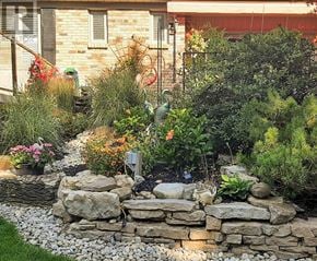 Hamilton (Waterdown) apartment for rent - A garden with a stone wall and a variety of plants.