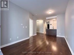 Oakville (Ro River Oaks) condo for rent - A spacious room with wooden floors and white walls.