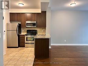 Oakville (Ro River Oaks) condo for rent - A kitchen with a refrigerator, microwave, oven and sink.