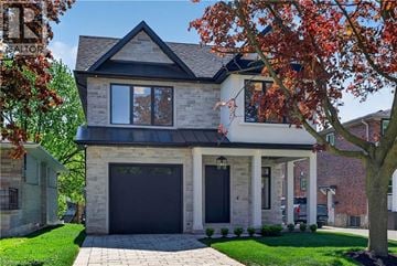 Oakville apartment for rent - A house with a black garage door and a stone facade.