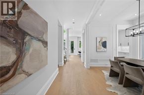 Oakville apartment for rent - A long hallway with a painting on the wall and a dining table with chairs.