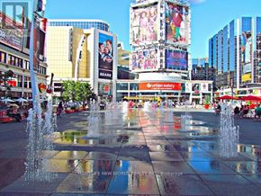 Toronto (Bay Street Corridor) condo for rent - A fountain in the middle of a plaza surrounded by tall buildings.
