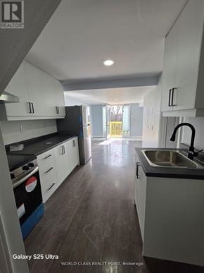 Oshawa (Pinecrest) apartment for rent - A kitchen with white cabinets and a black stove top oven.