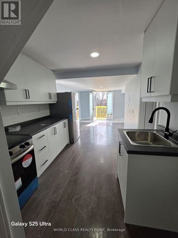 Oshawa (Pinecrest) apartment for rent - A kitchen with white cabinets and a black stove top oven.