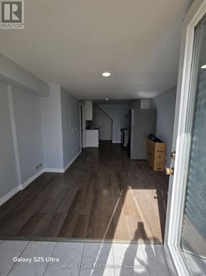 Oshawa (Pinecrest) apartment for rent - A room with wooden flooring and white walls, with boxes and a ladder in the background.