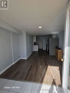 Oshawa (Pinecrest) apartment for rent - A room with wooden flooring and white walls is shown.