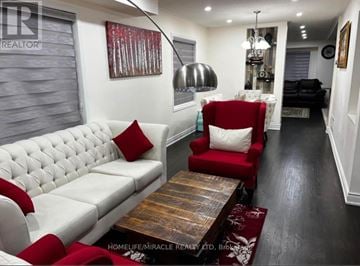 Brampton (Fletcher's Creek Village) apartment for rent - A living room with a white couch and red pillows.