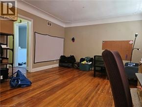 Hamilton apartment for rent - A room with a whiteboard, a chair, and some bags on the floor.