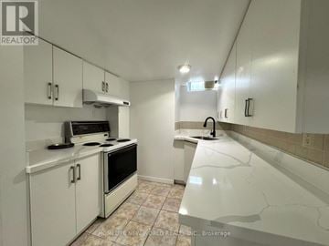 Toronto (Agincourt North) apartment for rent - A kitchen with white cabinets and a marble countertop.