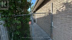 Toronto (Agincourt North) apartment for rent - A chain link fence with a gate is in front of a brick wall.