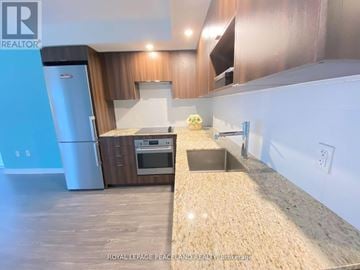 Toronto (Agincourt South-Malvern West) condo for rent - A kitchen with a blue refrigerator and wooden cabinets.