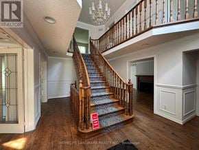 Aurora (Aurora Highlands) apartment for rent - A staircase with a wooden banister and a chandelier in a home.
