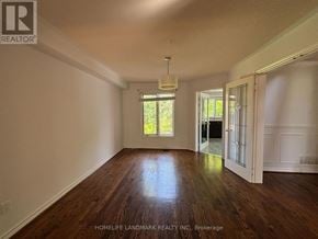 Aurora (Aurora Highlands) apartment for rent - A room with wooden floors and a window with a view of trees.