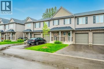 Waterloo townhouse for rent - A black car is parked in front of a house with a garage.