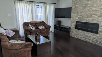 Gatineau (Aylmer) condo for rent - A living room with a brown couch and a stone fireplace.