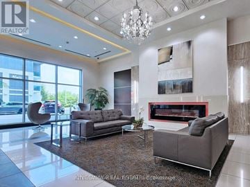 Markham (Grandview) condo for rent - A living room with a grey sofa and a fireplace.