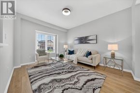 Innisfil (Alcona) apartment for rent - A well-lit living room with a rug, a couch, a chair, and a painting on the wall.