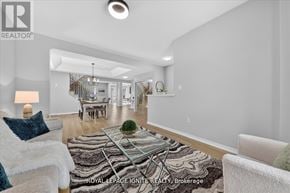 Innisfil (Alcona) apartment for rent - A well-lit living room with a white couch and a rug in the foreground.