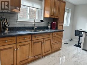 Mississauga (Cooksville) apartment for rent - A kitchen with wooden cabinets and a black countertop.