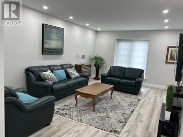 Mississauga (Cooksville) apartment for rent - A living room with a black couch and a wooden coffee table.